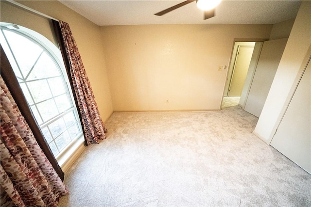 unfurnished bedroom featuring light carpet and ceiling fan