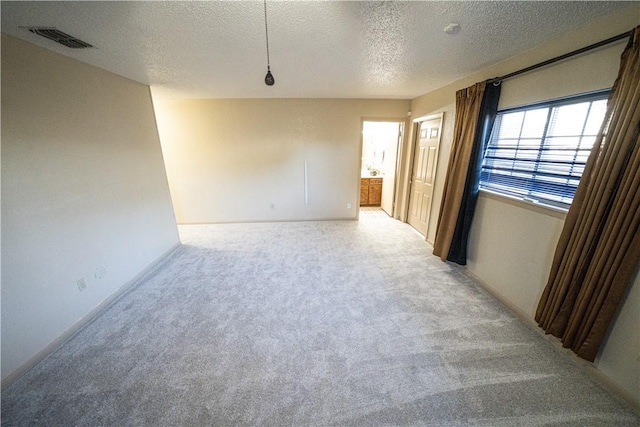 unfurnished room featuring carpet and a textured ceiling