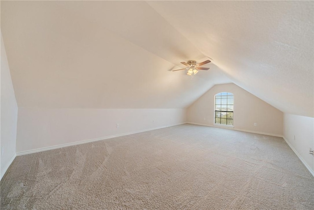 additional living space with baseboards, a ceiling fan, carpet, and vaulted ceiling