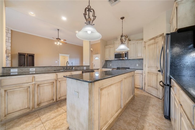 kitchen featuring light brown cabinets, appliances with stainless steel finishes, backsplash, a sink, and visible vents