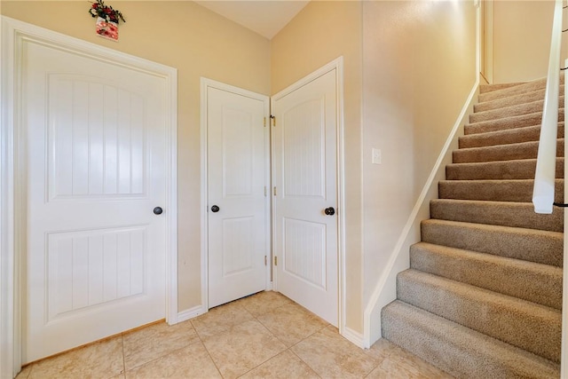 stairway with tile patterned flooring and baseboards