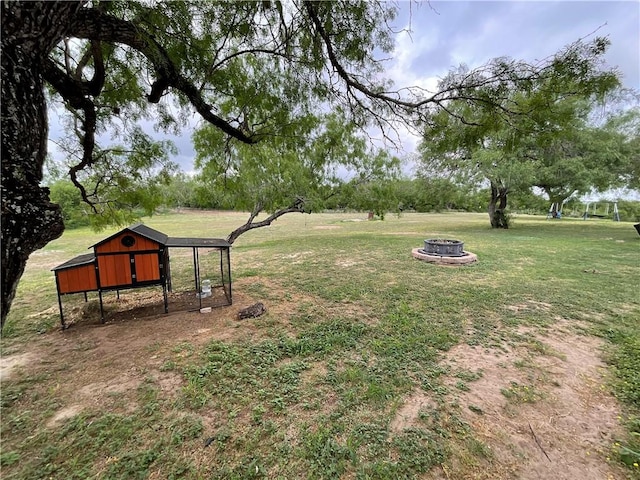 view of yard featuring an outdoor fire pit, exterior structure, and an outbuilding