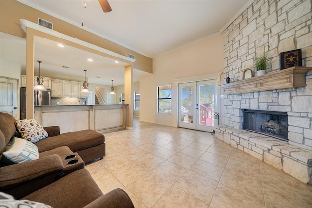 living area with crown molding, light tile patterned flooring, visible vents, and ceiling fan