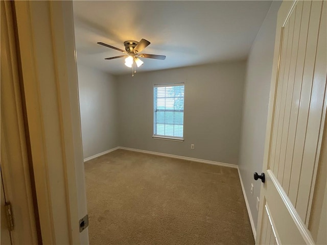 empty room with baseboards, a ceiling fan, and carpet flooring