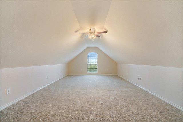 bonus room with a ceiling fan, vaulted ceiling, light colored carpet, and baseboards