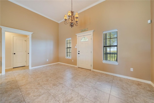 entrance foyer with a healthy amount of sunlight, ornamental molding, an inviting chandelier, and light tile patterned flooring