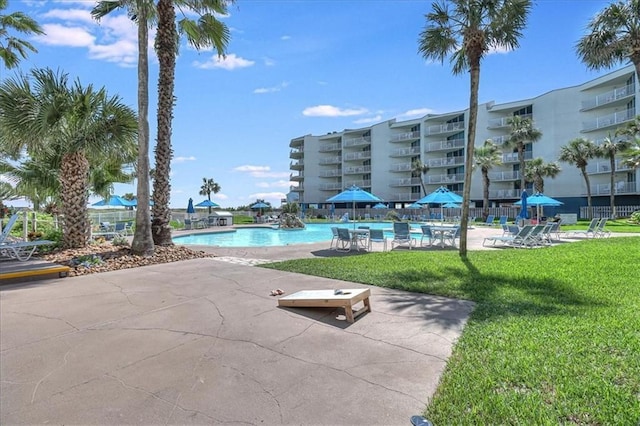 view of pool featuring a patio area and a yard