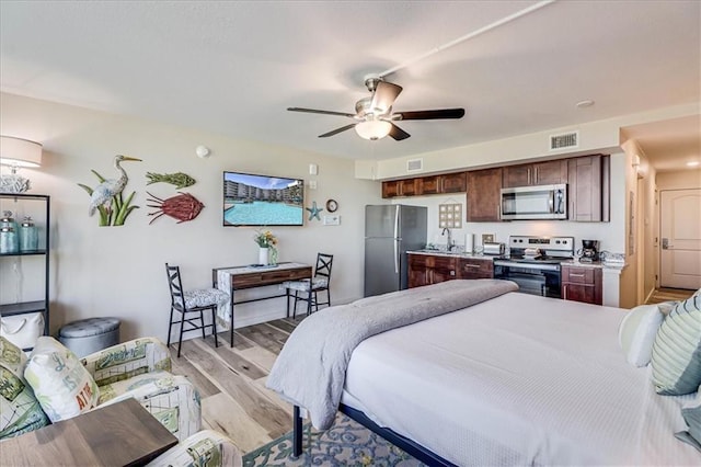 bedroom with stainless steel fridge, sink, ceiling fan, and light wood-type flooring