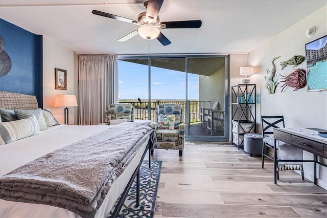 bedroom featuring access to exterior, light hardwood / wood-style flooring, ceiling fan, and floor to ceiling windows