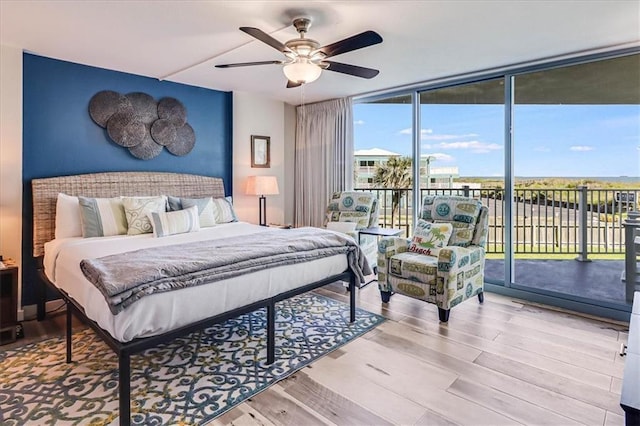 bedroom featuring floor to ceiling windows, light wood-type flooring, access to outside, and ceiling fan