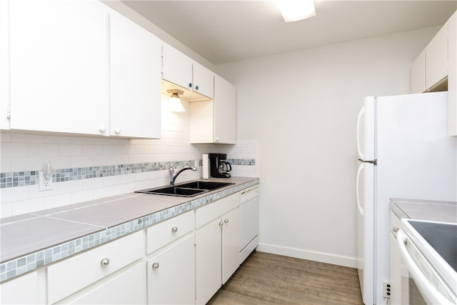 kitchen with decorative backsplash, sink, white cabinetry, light hardwood / wood-style flooring, and white appliances