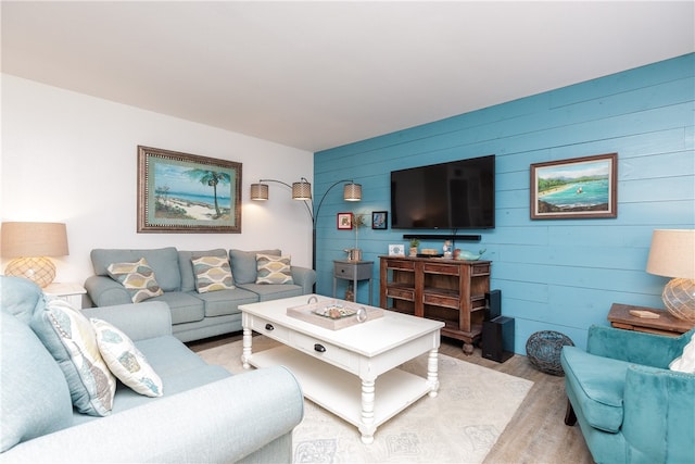 living room featuring wood walls and light hardwood / wood-style flooring