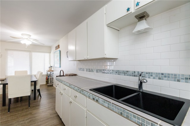 kitchen featuring sink, dark hardwood / wood-style floors, ceiling fan, backsplash, and white cabinetry