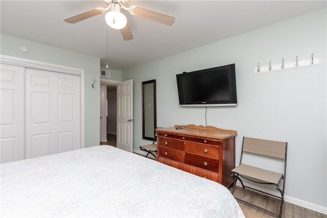 bedroom featuring wood-type flooring, ceiling fan, and a closet