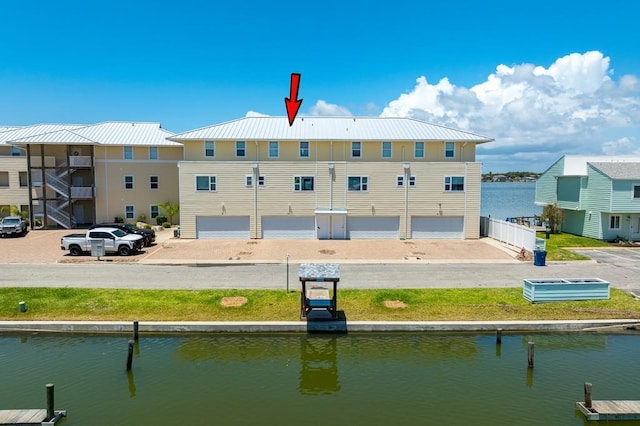 rear view of property featuring a water view and a garage