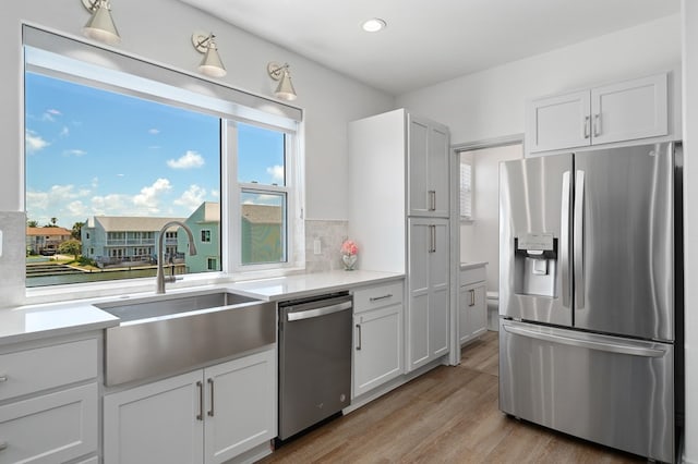 kitchen featuring white cabinetry, appliances with stainless steel finishes, and light hardwood / wood-style flooring