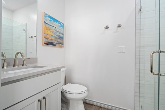 bathroom featuring hardwood / wood-style flooring, vanity, toilet, and walk in shower