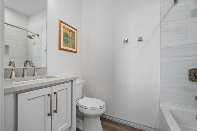 full bathroom featuring hardwood / wood-style floors, vanity, toilet, and tiled shower / bath combo