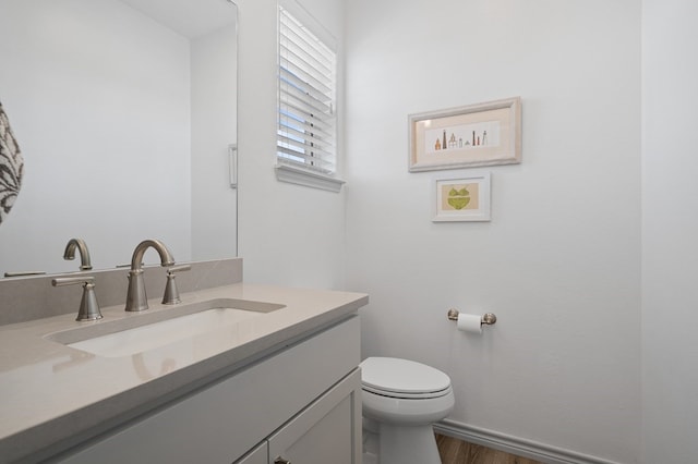 bathroom featuring vanity, hardwood / wood-style flooring, and toilet