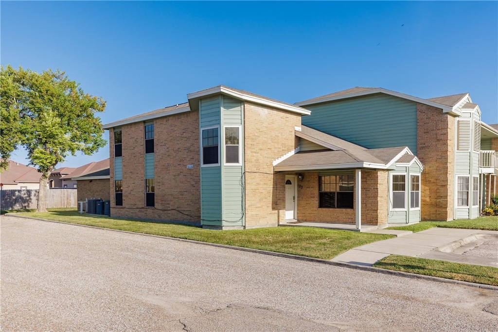 view of front of house with cooling unit and a front yard