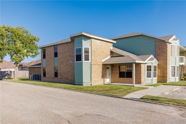 view of front of house with cooling unit and a front yard