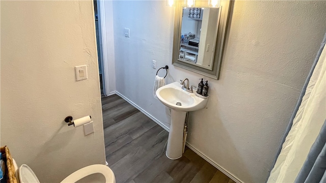 bathroom with toilet and hardwood / wood-style floors