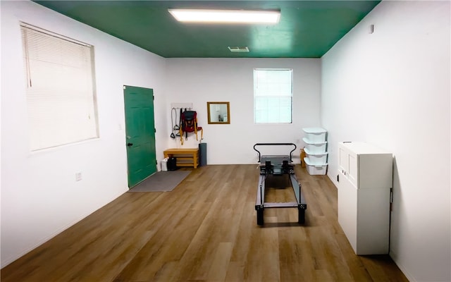 workout area with light hardwood / wood-style flooring