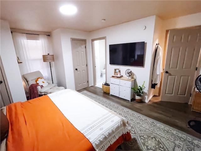 bedroom with ensuite bathroom and dark hardwood / wood-style flooring