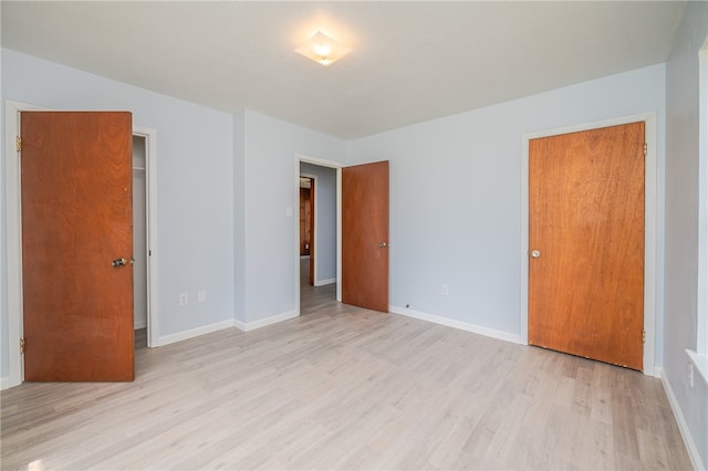 unfurnished bedroom with a closet and light wood-type flooring