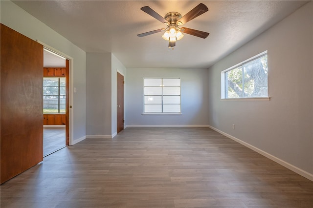 unfurnished room featuring light wood-type flooring, a textured ceiling, and ceiling fan