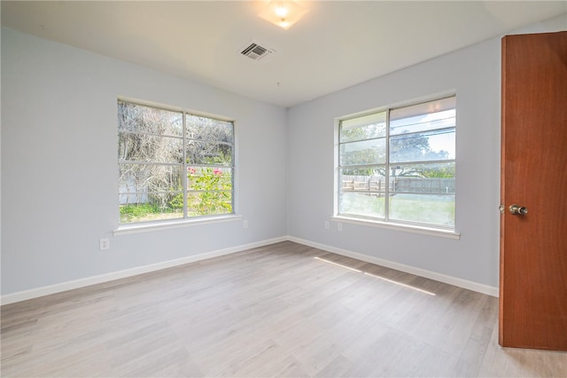 spare room featuring plenty of natural light and light hardwood / wood-style floors