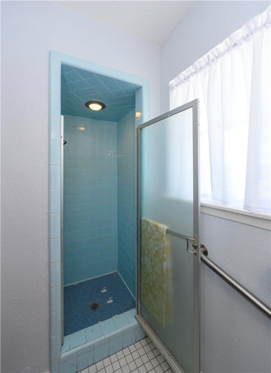 bathroom with tile patterned flooring and tiled shower