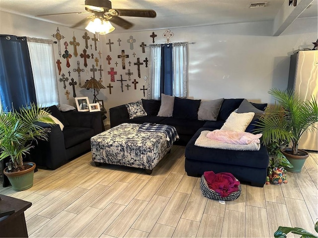 living room featuring ceiling fan and a healthy amount of sunlight