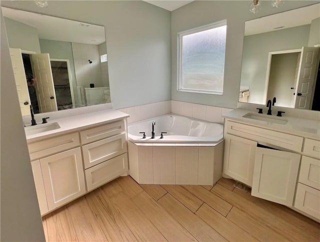 bathroom with vanity, hardwood / wood-style floors, and separate shower and tub