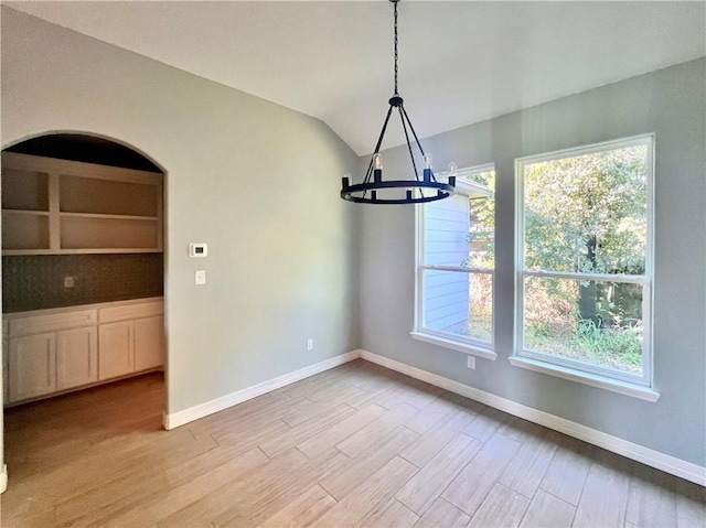 10773 Westview Dr, Corpus Christi, TX 78410 - unfurnished dining area with a chandelier, baseboards, light wood-style floors, plenty of natural light, and lofted ceiling