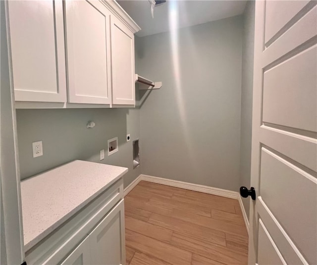 washroom featuring electric dryer hookup, washer hookup, cabinets, and light wood-type flooring