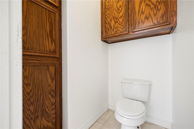 bathroom with tile patterned flooring, toilet, and baseboards