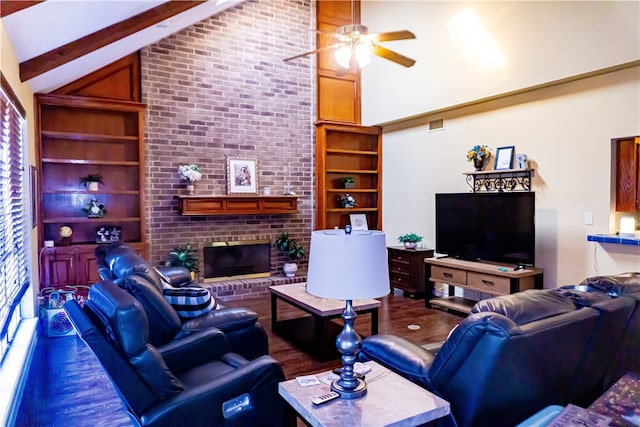 living area featuring wood finished floors, beam ceiling, built in shelves, and a ceiling fan