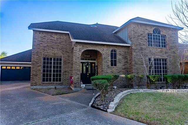 view of front of property with brick siding, concrete driveway, an attached garage, and a shingled roof