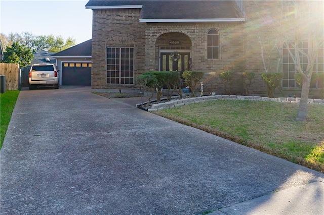 view of front of property featuring a front lawn, concrete driveway, a shingled roof, a garage, and brick siding