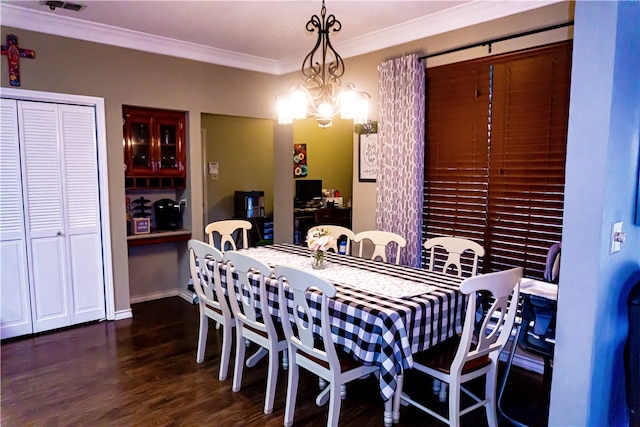 dining room featuring crown molding, baseboards, and wood finished floors