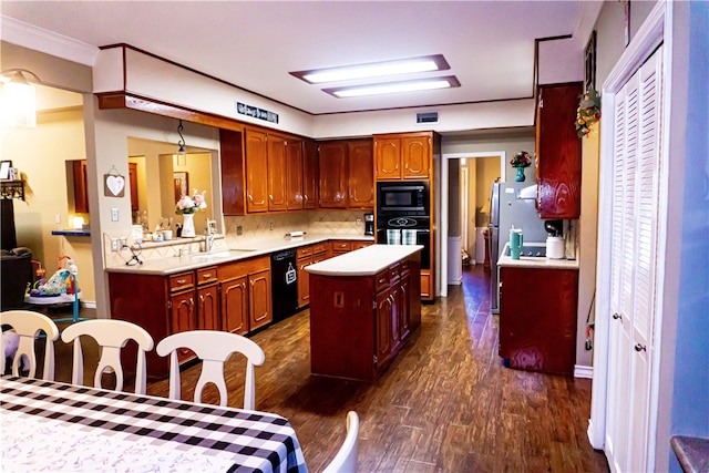 kitchen featuring a sink, black appliances, light countertops, dark wood-type flooring, and a center island