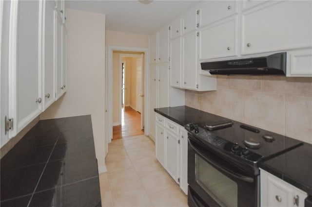 613 Brawner Pkwy, Corpus Christi, TX 78411 - kitchen with black electric range oven, under cabinet range hood, white cabinets, decorative backsplash, and dark countertops