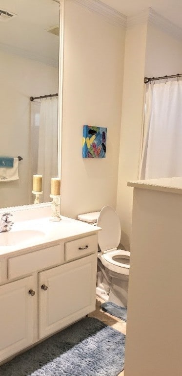 bathroom with ornamental molding, walk in shower, vanity, and toilet