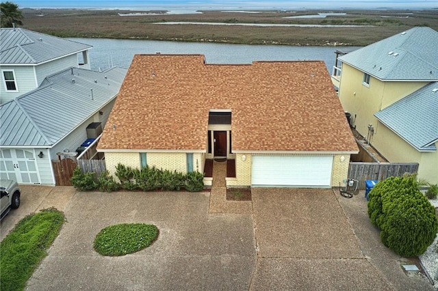 15849 El Soccorro, Corpus Christi, TX 78418 - view of front of property with concrete driveway, brick siding, fence, and a water view