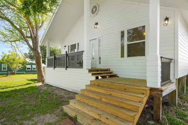 view of exterior entry with a yard