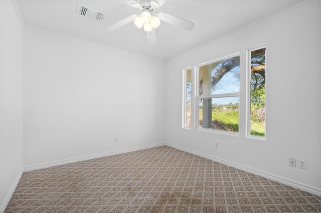 carpeted spare room with ceiling fan and crown molding