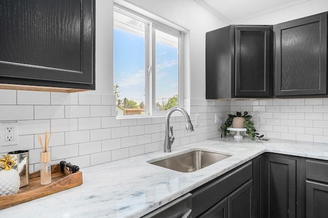 1179 Houston St S, Aransas Pass, TX 78336 - kitchen with dark cabinetry, tasteful backsplash, ornamental molding, and light stone countertops