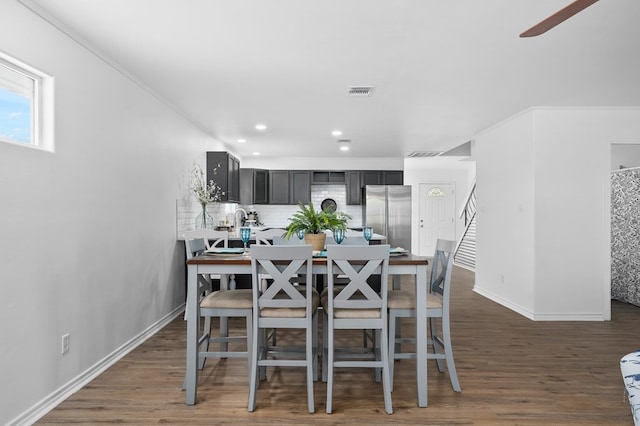 dining room with ornamental molding and dark wood-type flooring