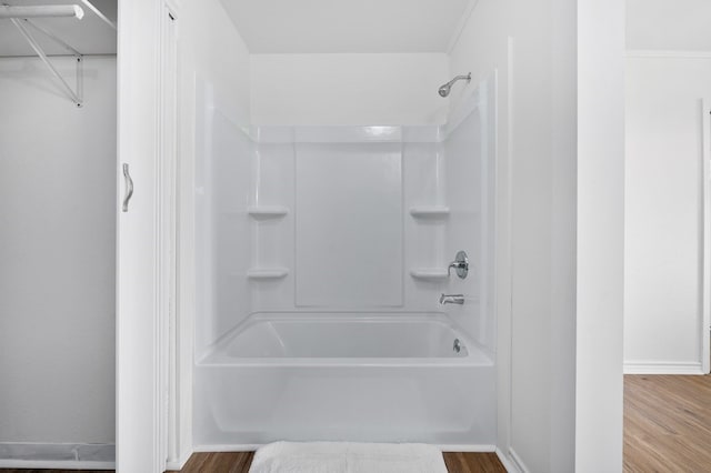 bathroom with wood-type flooring and tub / shower combination